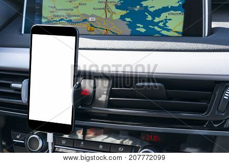 Smartphone in a car use for Navigate or GPS. Driving a car with Smartphone in holder. Mobile phone with isolatede white screen. Blank empty screen. copy space. Empty space for text. modern car interior details.