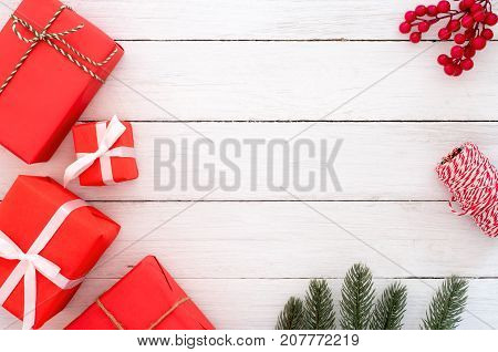 Christmas composition. Christmas present gifts boxes and fir leaves with decoration rustic elements on white wooden background. Creative flat lay top view design