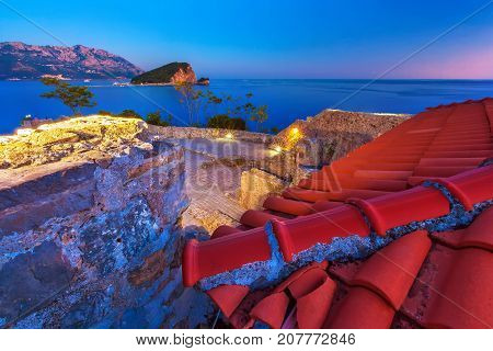Brown roof tiles on the fortress. Citadela Old Budva night view. Montenegro.