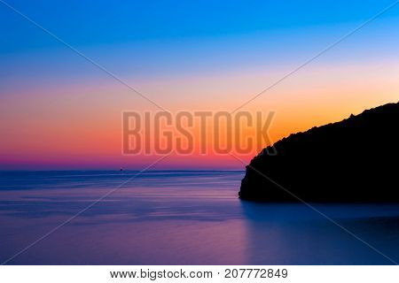 Colorful sunset on the sea with the silhouette of the mountain on the right. View from Citadela Old Budva. Montenegro.