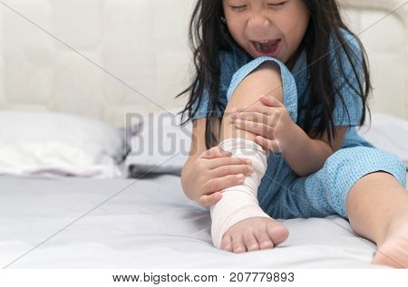Foot Pain. Little Kid With Broken Leg On Bed,