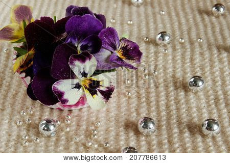 Still life with a pansy a bouquet of flowers tied with ribbon and strewn with beads