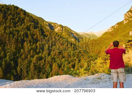 The man takes pictures in mountains of Olympus.