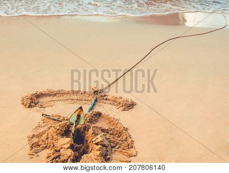 An anchor is dug securely into a sandy beach.
