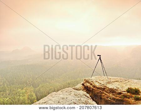 Tripod On The Peak Ready For Photogrpahy. Exposed Rocky View Point. Misty Rainy Autumnal Day