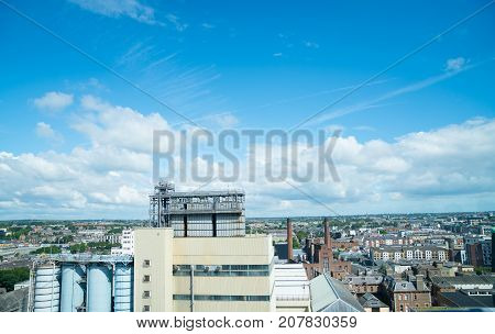 Dublin urban area stretching to distant horizon under blue sky with white clouds.