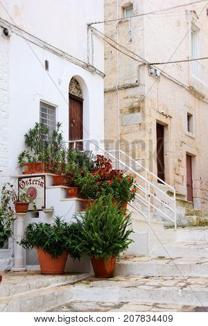 Lane in the white city, Ostuni, Apulia, Italy. Osteria means 