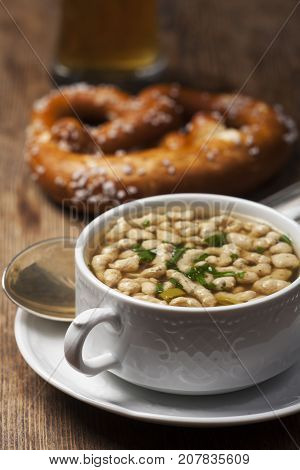 portion of bavarian bratnockerl soup with prezel