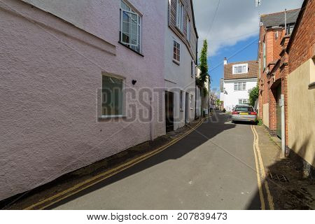 Very narrow street in Topsham. A car is parked on the road. Devon. UK