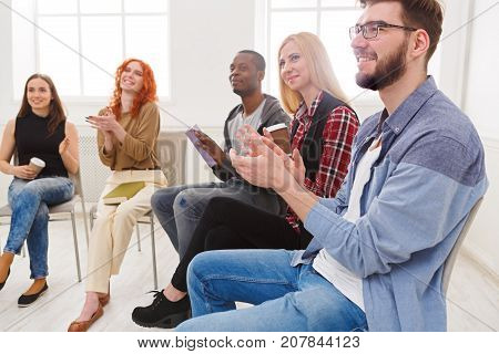 Meeting of support group. Company of people sitting in circle and clapping to speaker, psychotherapy background