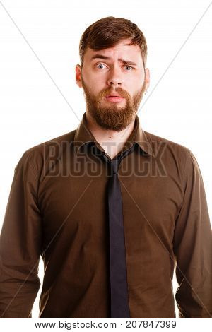 Attractive young man with beard in brown shirt and black tie man shows emotion of wonder on camera in studio isolated on a white background.