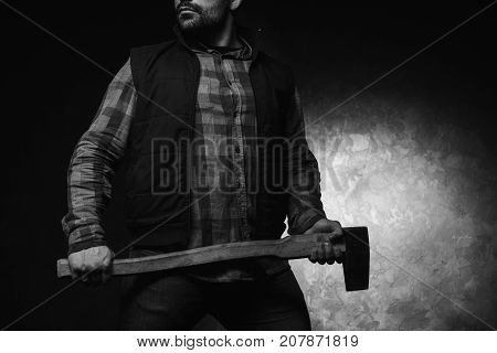 Confident axeman. Armed man with axe. Dangerous unrecognizable rural man on black background closeup, protection concept