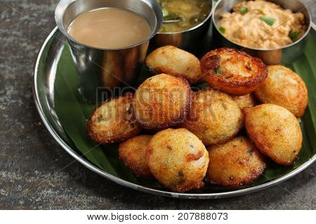 Kuzhi Paniyaram served with coconut chutney and sambar- South Indian breakfast with black lentils and rice