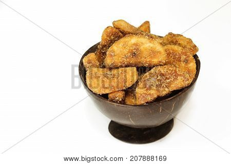 Sharkara Varetti served in coconut shell bowl on white background