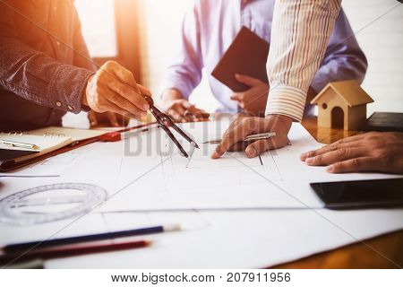 Consultation between colleagues engineering team to check the blueprint used to build commercial buildings for joint ventures.