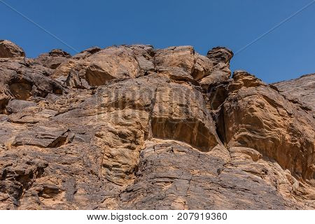 A rock cliff with the pre-islamic inscriptions at the north entrance of Wadi Massal, Riyadh Province, Saudi Arabia