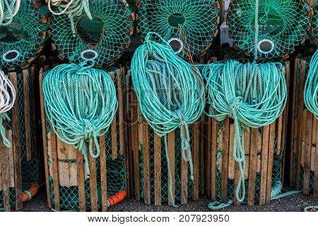 Lobster traps standing on a pier prepared for fishing with ropes and buoys in a Norwegian fishing village