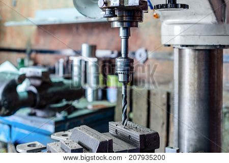 Drilling machine. The drill bit is installed in the drill chuck. Machine vice, metalworking shop.
