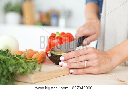 Hands Of Young Woman Cutting Fresh Vegatebles In The Kitchen.