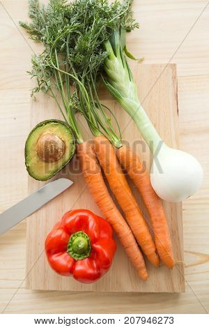 Close-up of fresh vegetables under wood background.