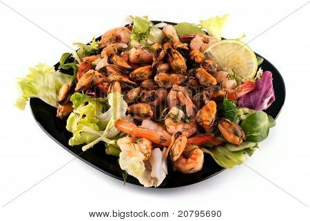 Un'insalata con frutti di mare su un piatto nero