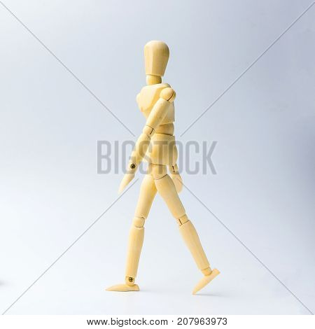 Wooden figure doll with walking action for business concept on white background.