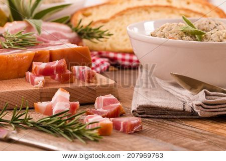 Canederli pasta with bacon on wooden table.