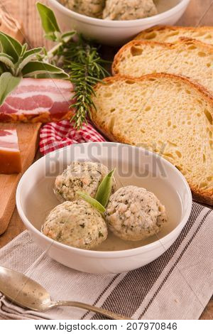 Canederli pasta with bacon on wooden table.