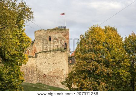 The ruins of the Livonia Order Castle was built in the middle of the 15th century. Bauska Latvia in autumn. Latvian flag on the top of the tower