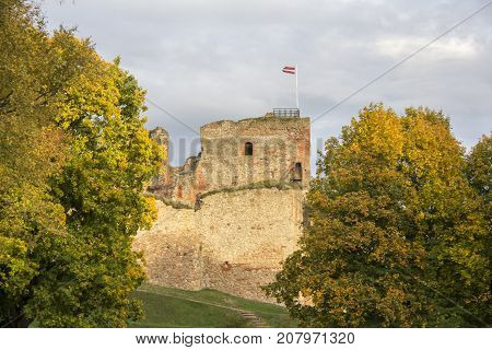 The ruins of the Livonia Order Castle was built in the middle of the 15th century. Bauska Latvia in autumn. Latvian flag on the top of the tower