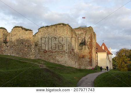 The ruins of the Livonia Order Castle was built in the middle of the 15th century. Bauska Latvia in autumn. Latvian flag on the top of the tower