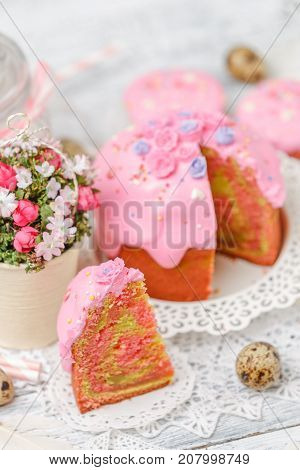 Traditional Easter cake with decorations and cupcakes on wooden table