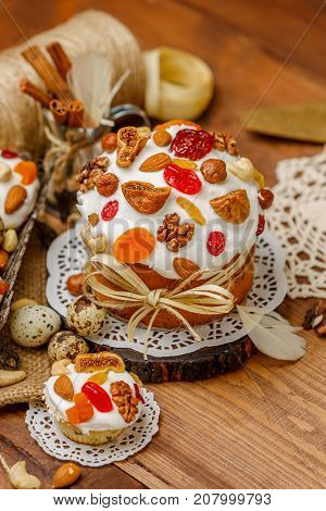 Traditional Easter cake with decorations and cupcakes on wooden table