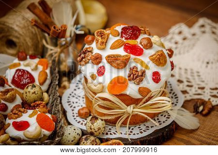 Traditional Easter cake with decorations and cupcakes on wooden table