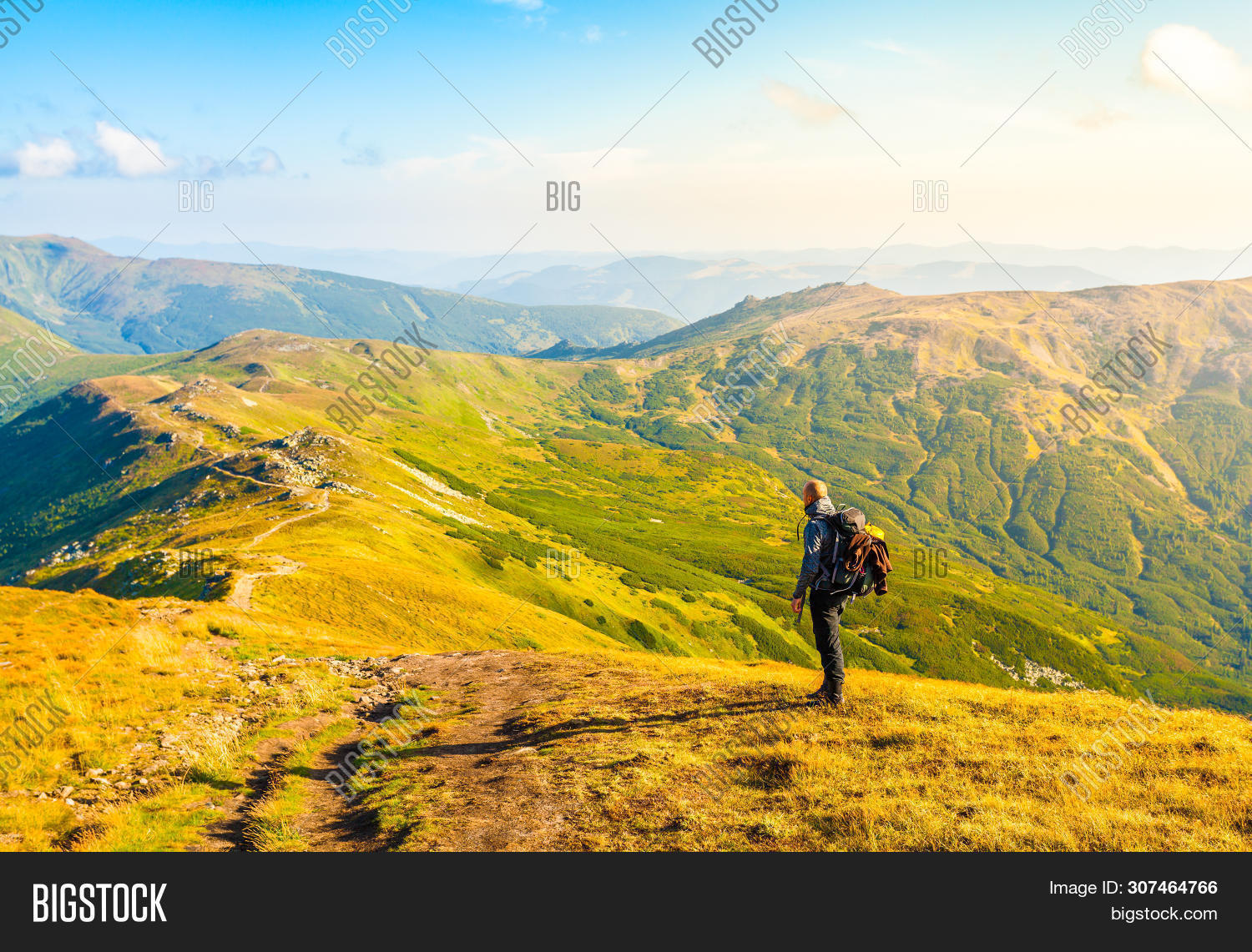 traveler carrying backpack on mountain trail