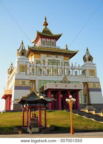 Male Tourist Stands Near The Buddha Statue Next To A Beautiful Buddhist Temple