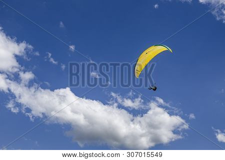 Oostduinkerke, Belgium - June 19, 2019: A Paraglider Is Floatring In The Air Between Wihte Clouds