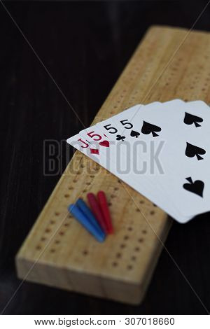 Playing Cards And Cribbage Board On Black Background