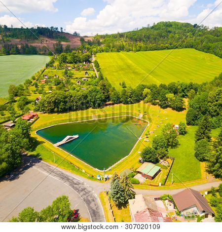 Aerial view to swimming pool and water reservoir in beautiful landscape close Kdyne town. Popular recreational area in Western Bohemia. Czech Republic, Europe.