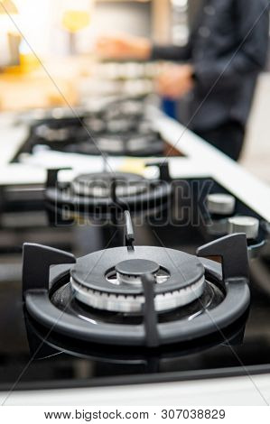 Modern Black Gas Stove On Countertop In Kitchen Showroom. Cooking Appliance In Domestic Kitchen. Hom