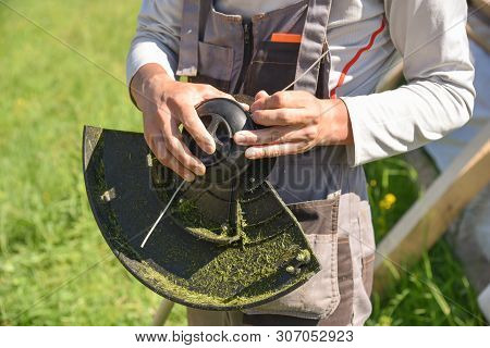 Trimmer Close Up Mow The Grass With A Lawnmower. Gardening With A Brush Cutter Close-up. Lawn Care W