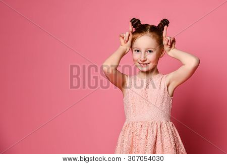 Smiling Young Crazzy Red Hair Kid Girl Having Fun And Making Horns By Her Hands, Looking At The Came