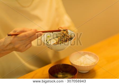 Senior woman eating natto at dinner
