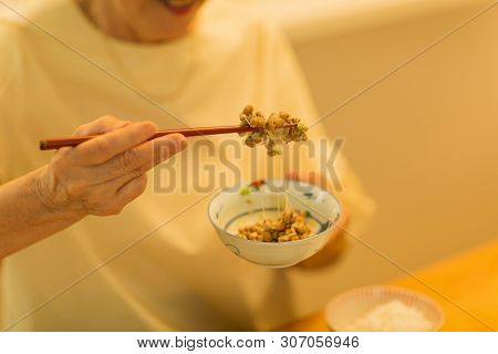 Senior woman eating natto at dinner