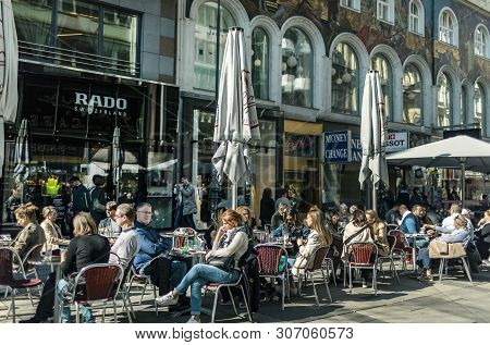 Viena, Austria - March 18, 2019: Relaxed People At The Cafe On The Central Viennese Street