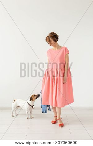 Pet And People Concept - Young Woman In Pink Dress With Jack Russell Over The White Background
