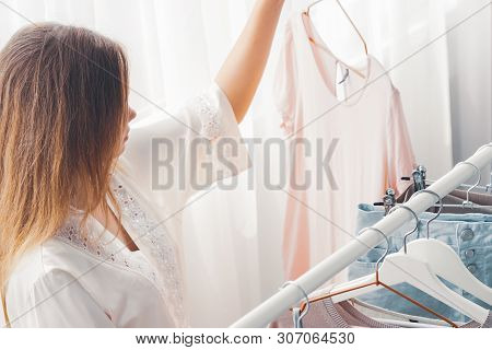 Clothing, Fashion, Style And People Concept - Woman Choosing Clothes At Home Wardrobe