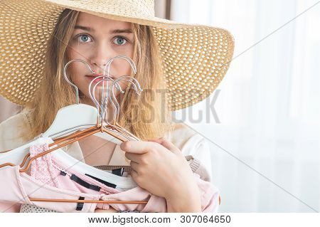 Woman Can Not Choose Which Clothes Pack For Travel. Clothing, Fashion, Style And People Concept - Wo