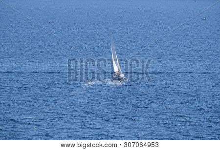 PORTOROZ, SLOVENIA - JUNE 26: White sailboat on open blue sea in Portoroz, Slovenia, on June 26, 2015.
