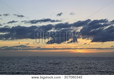 Scenic Sunset Over The Sea. The Sun Sets On The Water. Clouded Sky Is Painted With Bright Colors. Su